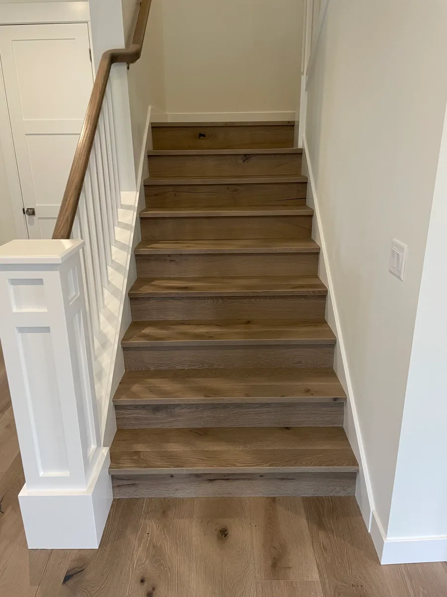 Hardwood stair treads with a white painted railing
